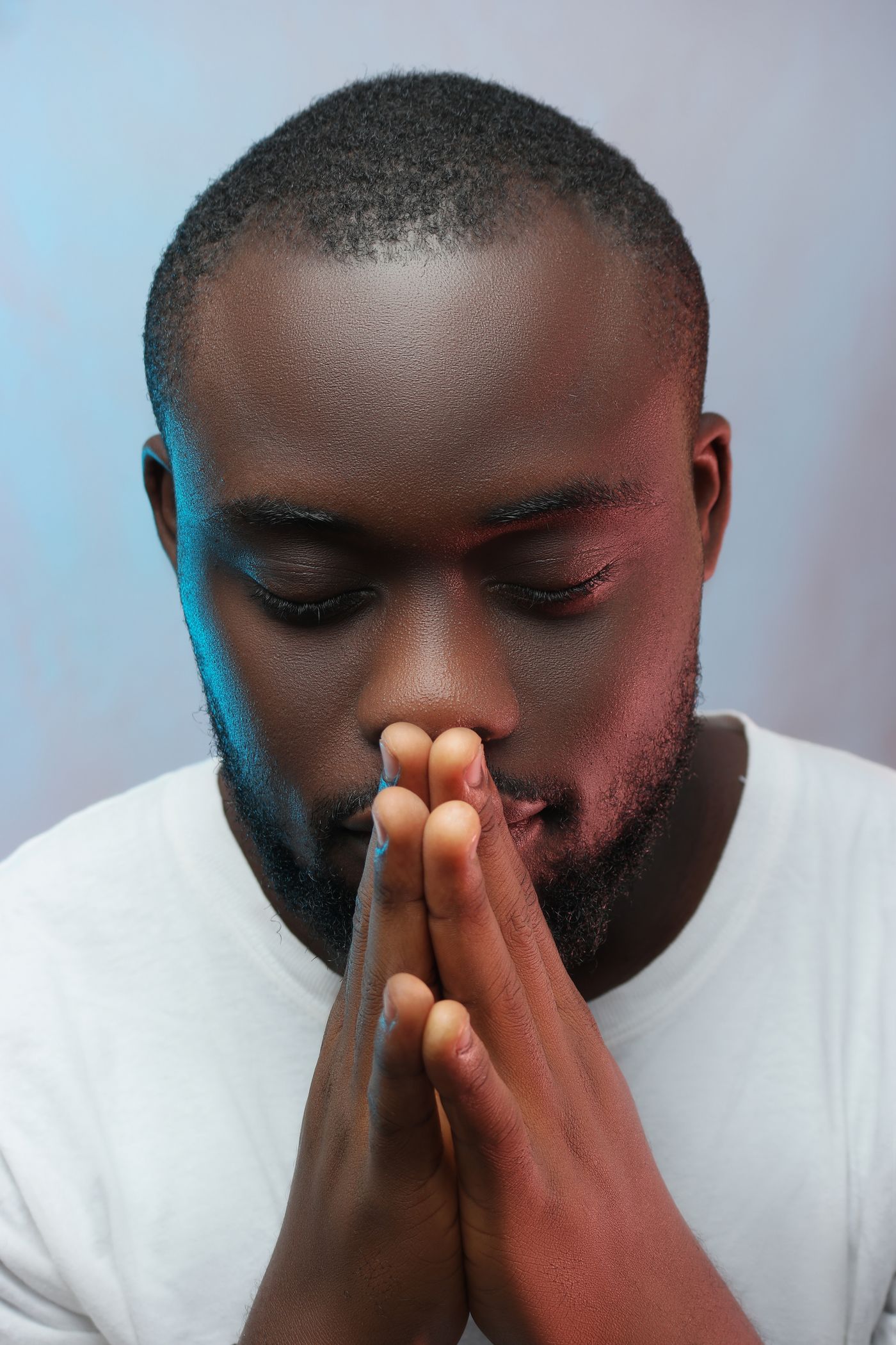 Man with eyes closed, hands together, breathing calmly