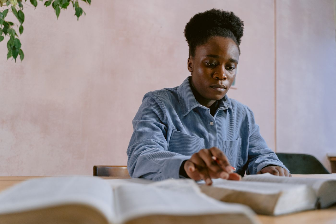 Woman studying an open Bible at a table