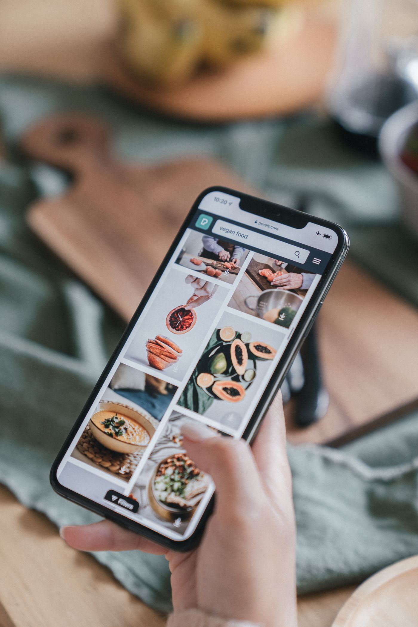 Holding a phone full of recipe videos in a kitchen